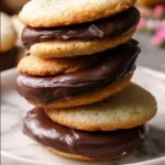 Delicious homemade Berger Cookies with chocolate frosting and coconut flakes.