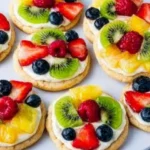 Colorful fruit pizza cookies topped with fresh fruit and creamy frosting