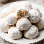 Snowball Cookies Recipe 5 Delicious snowball cookies arranged on a plate, dusted with powdered sugar.